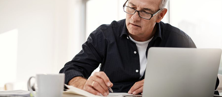 man sitting at laptop looking at home loan
